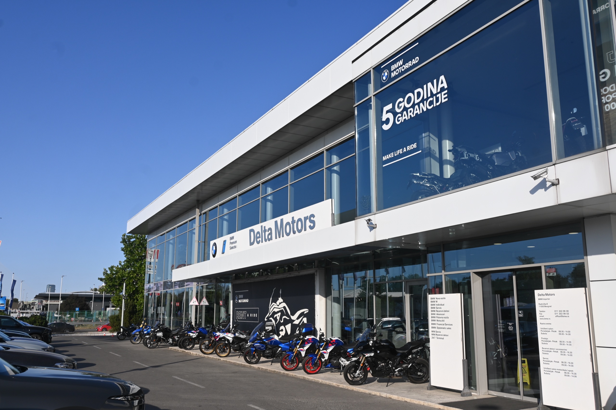 Auto salon BMW & MINI — bočna staklena fasada sa izloženim motociklima ispred