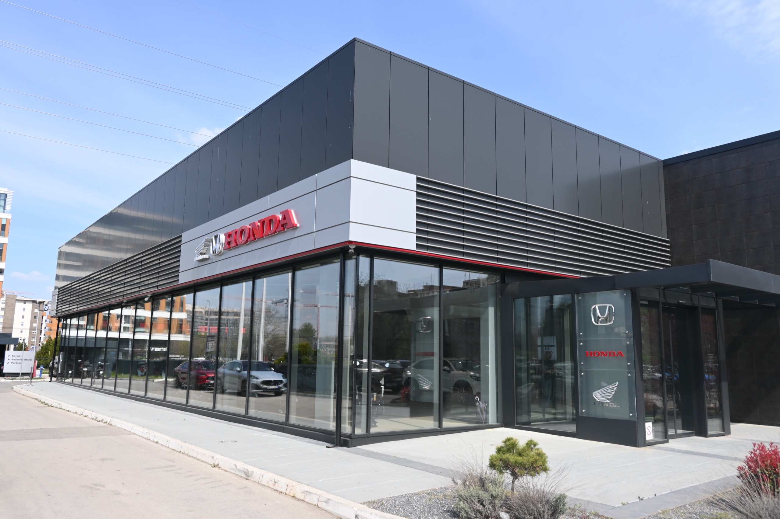 Auto salon Honda — ugao salona sa staklenim izlogom prizemlja i tamnom fasadom sprata