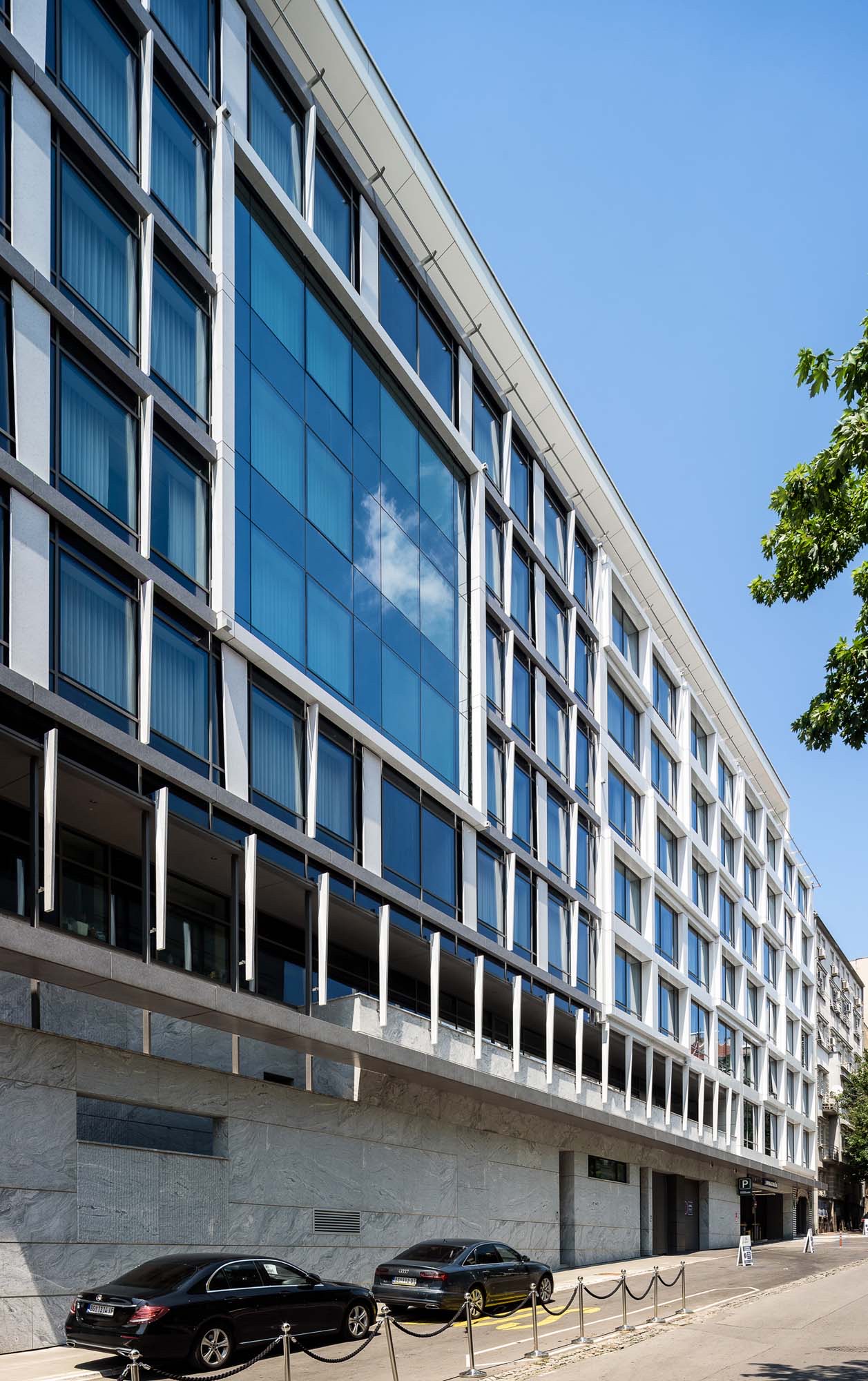 Hotel Hilton Beograd — staklena fasada sa lamelama i staklene ograde, pogled sa ulice