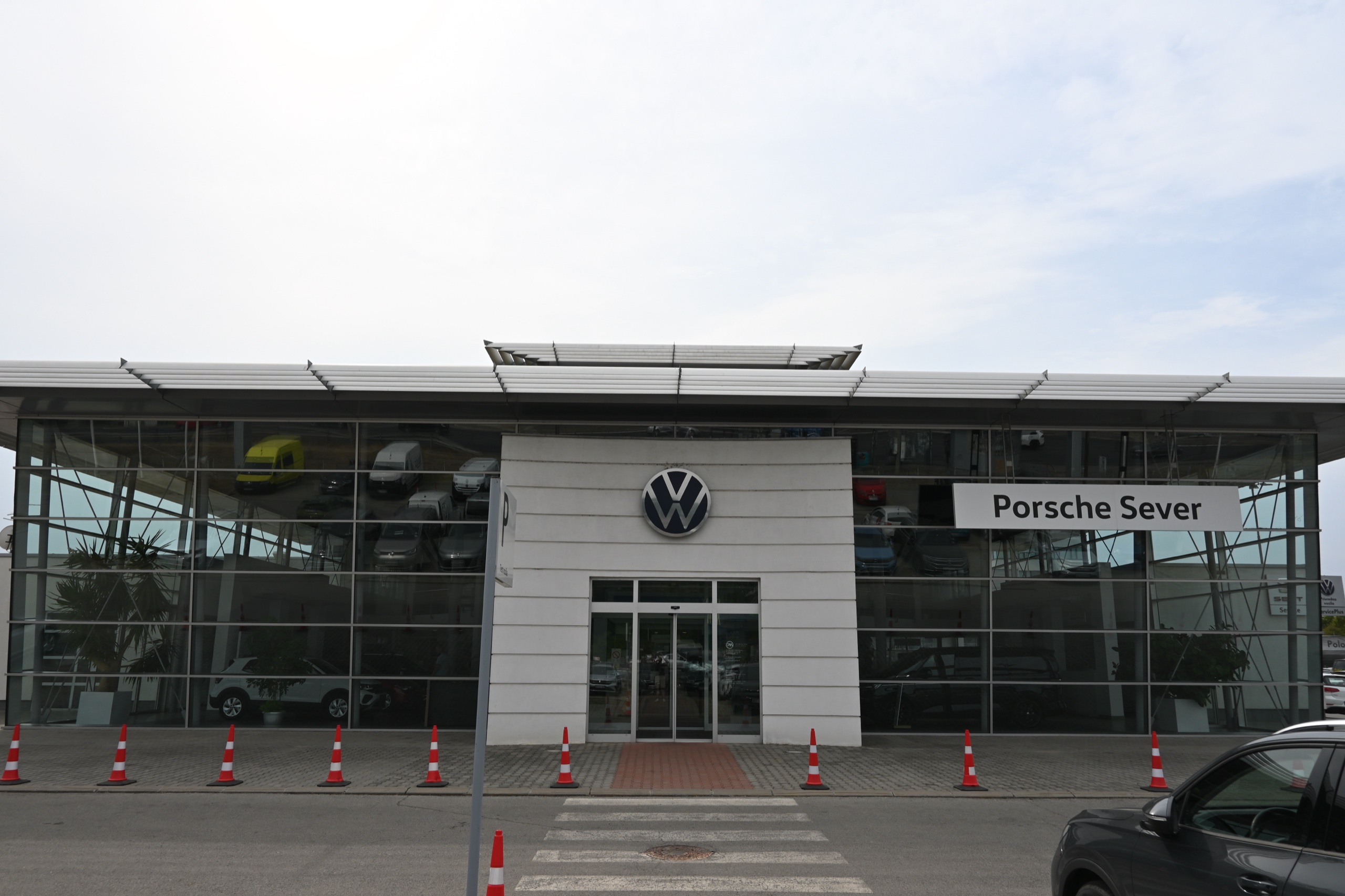Auto salon Volkswagen — čeona staklena fasada sa belim ulaznim portalom i VW znakom